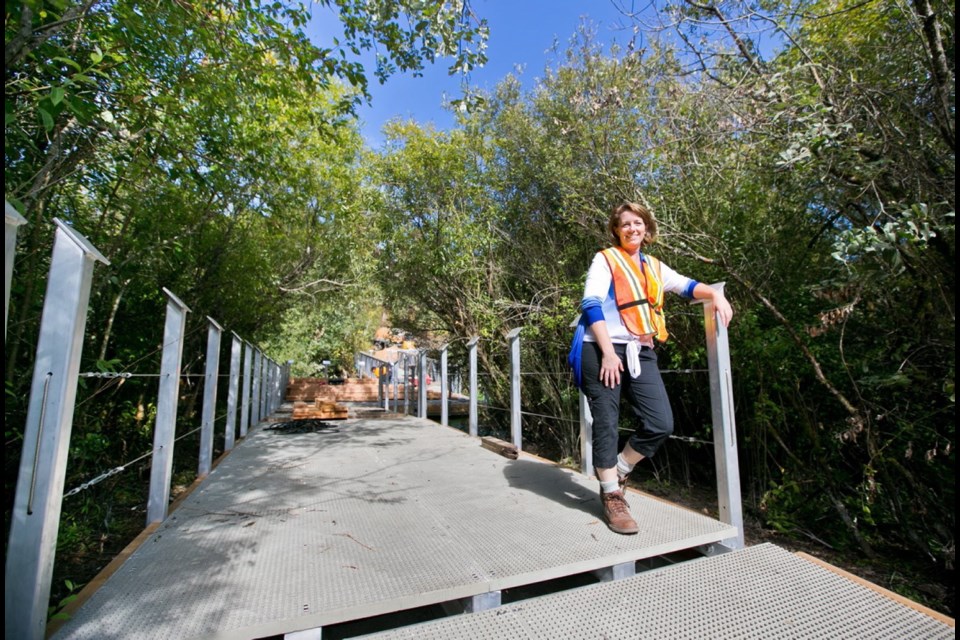 Kathleen Burton, executive director of the Swan Lake Nature Sanctuary Society, on a section of the sanctuary&Iacute;s floating walkway that was renovated in 2015.