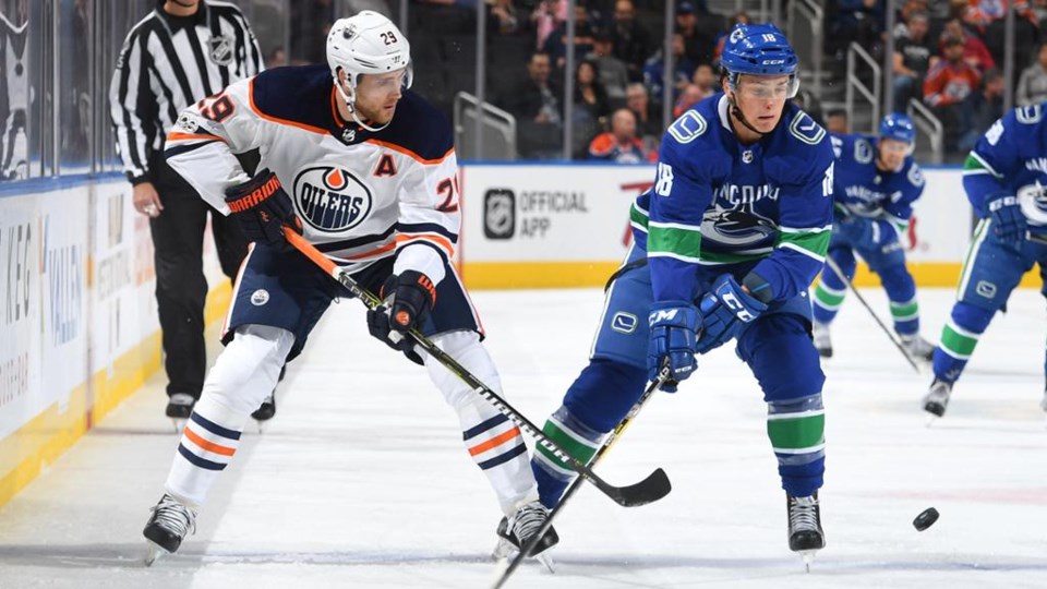 Jake Virtanen skates the puck in for the Canucks against the Oilers