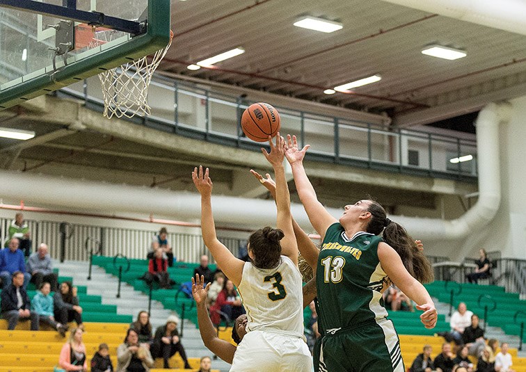 UNBC Timberwolves point guard Vasaliki Louka and University of Regina Cougars point guard Lauryn Prokop both jump for a loose ball on Saturday night at Northern Sport Centre. Citizen Photo by James Doyle