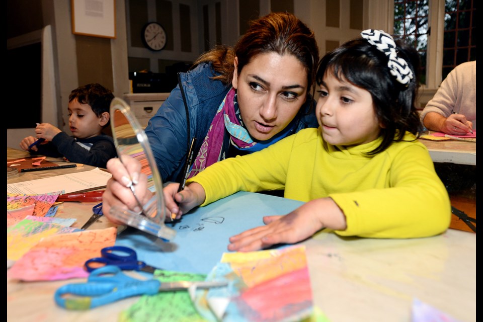 Hanieh Khakbiz and Maneli Sam, 6, work on their collage project.