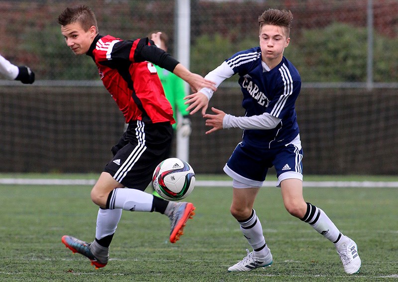 MARIO BARTEL/THE TRI-CITY NEWS
Archbishop Carney's Thomas Powell and Lucas Borejszo of St. Thomas Aquinas battle for position on the ball in the first half of their bronze medal match at the BC Secondary Schools Soccer Commission AA provincial finals, Wednesday at the Burnaby Lake Sports Complex. St. Thomas Aquinas won the match 2-1.