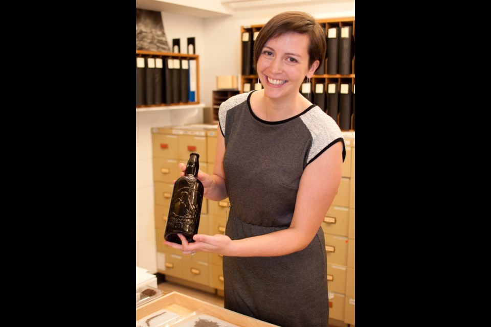 UVic archeology professor Katherine Cook holds a brown glass bottle, produced for Tooth and Co., a large Australian brewer whose goods were finding their way to Victoria in the mid 1800s.