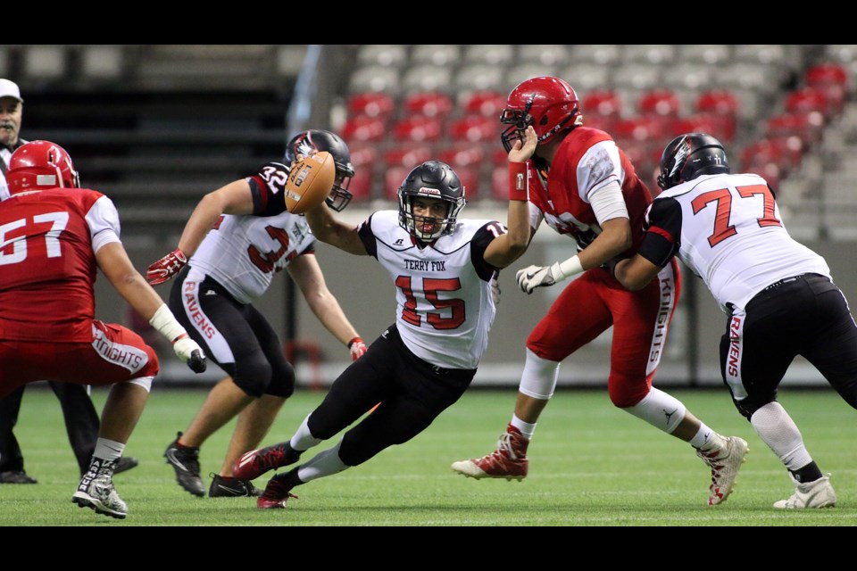 Terry Fox Ravens’ Jevaun Jacobsen, centre, dives through the St. Thomas More defence en route to the end zone during Saturday’s B.C. AAA football semifinal at BC Place.