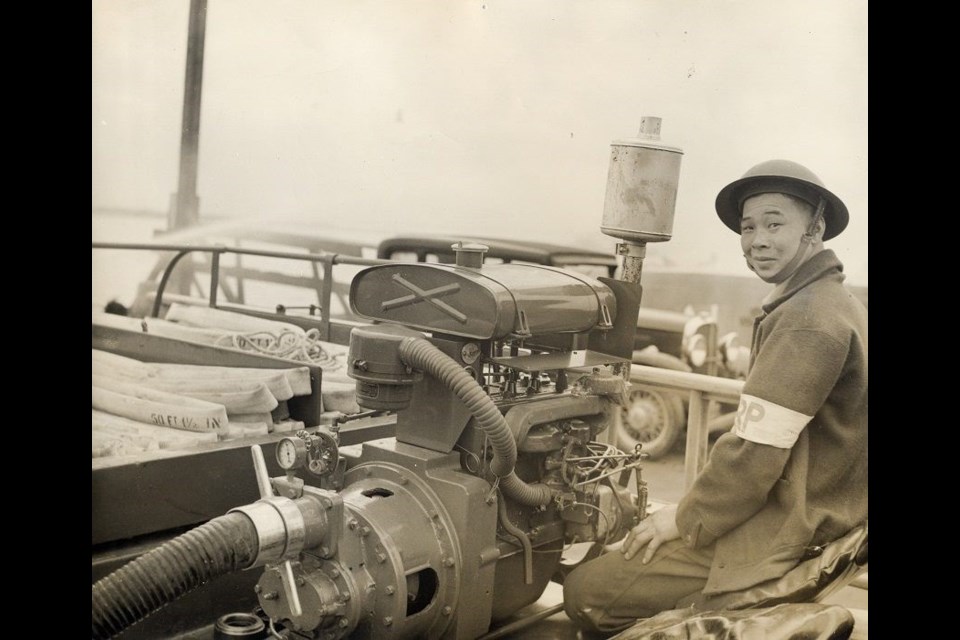 In 1942, the 15-man Steveston Volunteer Fire Department spent $200 installing pumping equipment on a truck to create the first Air Raid Precaution Unit in Canada. Shown here operating the pump is Harry Hing, who designed and built the truck. Photo by City of Richmond Archives.