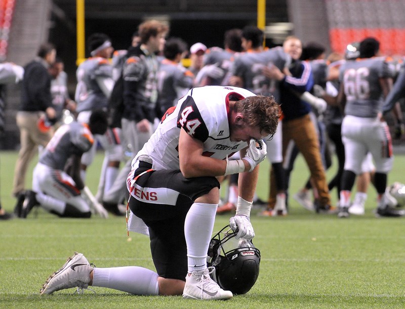 MARIO BARTEL/THE TRI-CITY NEWS
Terry Fox Ravens' defensive lineman is disconsolate at the New Westminster Hyacks celebrate their last-second 15-14 victory in Saturday's BC Secondary Schools Football Association Subway Bowl AAA championship at BC Place.