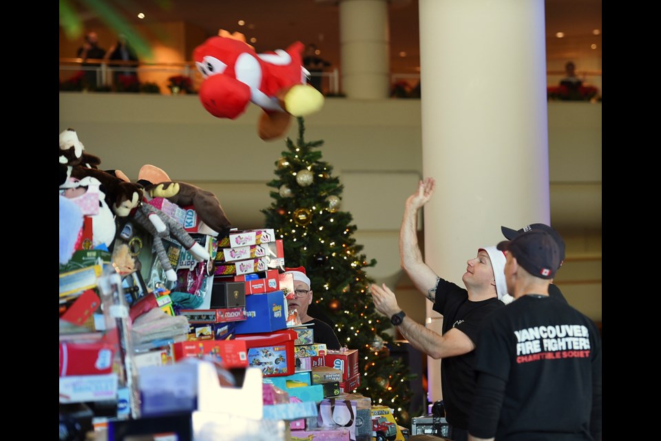Volunteers from the Vancouver Fire Department help stack toys at the Christmas Wish Breakfast at the Pan Pacific Vancouver Hotel last year.