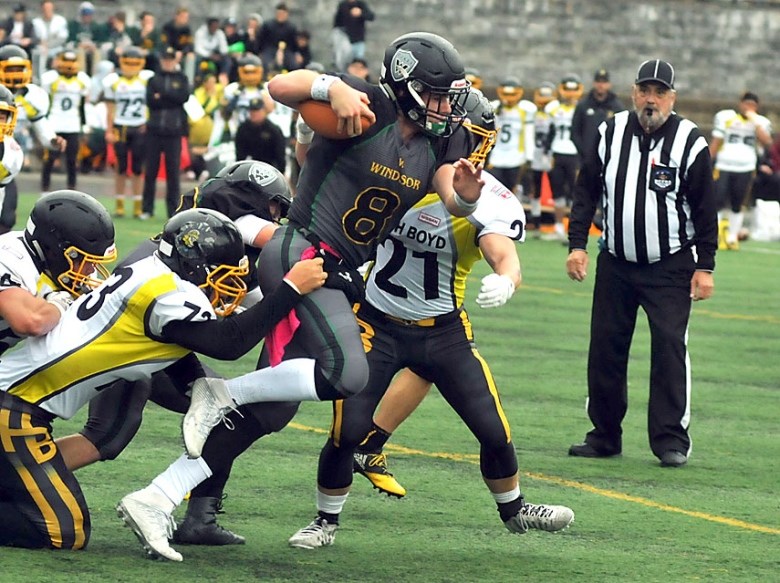 Windsor quarterback Ryan Baker fights off a pack of tacklers during a home game earlier this season. Baker was named game MVP after leading the Dukes to a 44-29 win over Abbotsford in the provincial final Saturday at BC Place. photo Paul McGrath, North Shore News