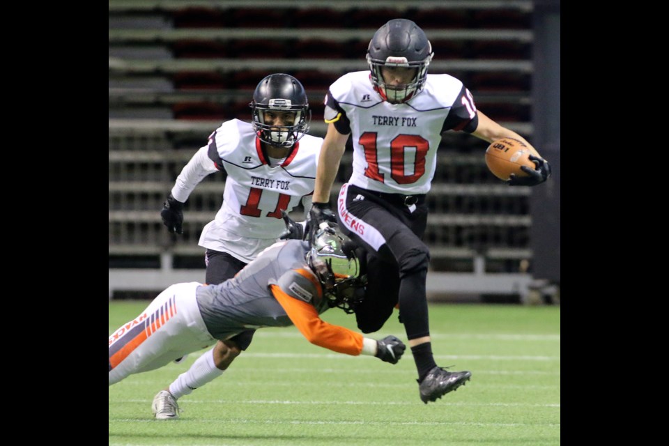 Terry Fox Ravens running back Cade Cote steps past New Westminster Hyacks tackler Severio Asaba to break an 89-yard touchdown run late in the second quarter of their BC Secondary Schools Football Association AAA Subway Bowl final Saturday at BC Place Stadium.