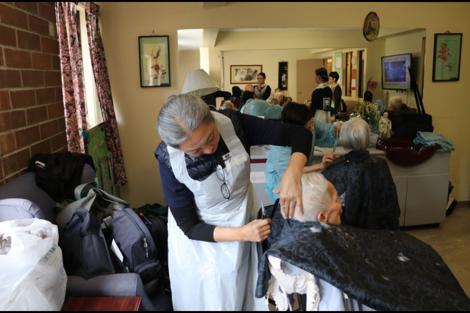 Volunteers from the Tzu Chi Foundation Canada giving free haircuts to seniors.