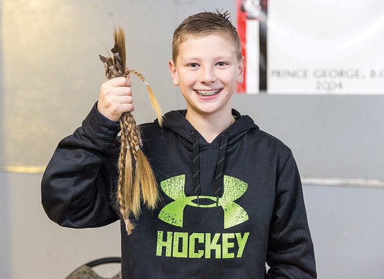 Braden Flett, a grade eight student at Duchess Park Secondary shows off the hair he cut off on Saturday night during the first intermission at the Prince George Spruce Kings game. Citizen Photo by James Doyle