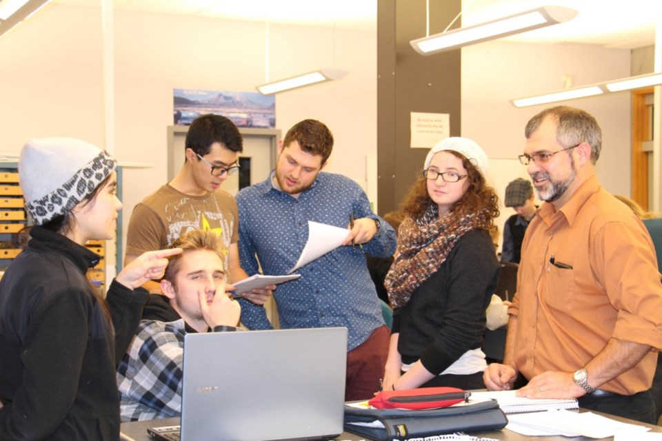 Earth sciences professor Glyn Williams-Jones, right, confers with the students on the 'Geological Survey of Canada' team during the volcanic simulation exercise.