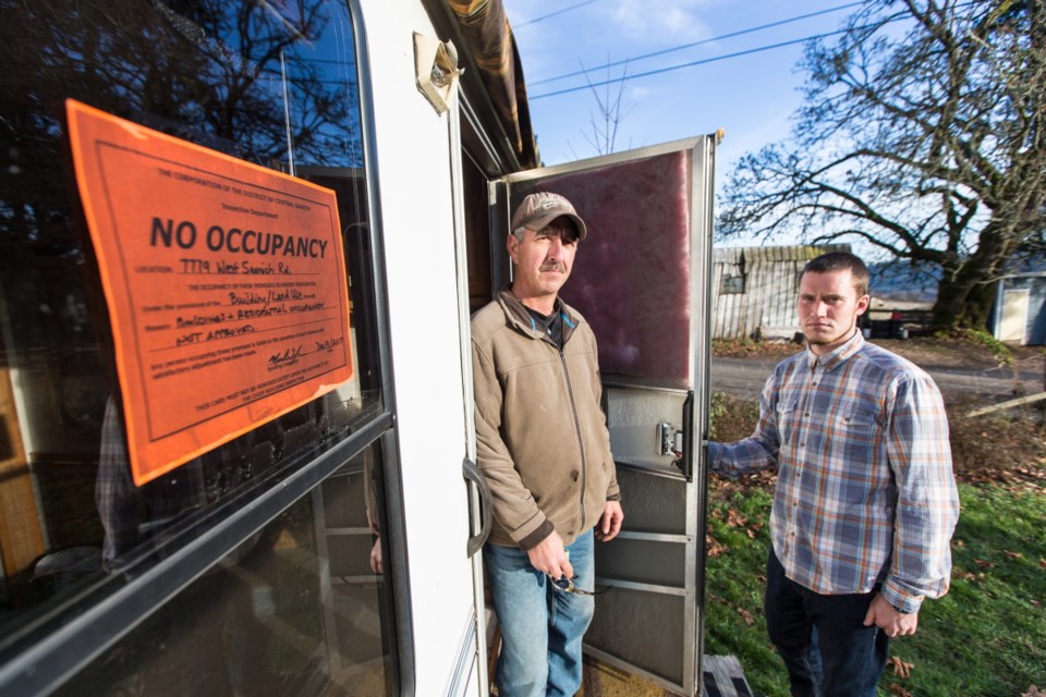 Residents Dan Fortin, left, and Ryan Colwell with a no-occupancy sign that was attached to their recreational vehicle at Woodwynn Farms. Fortin says he has lived in the RV for the past two years and has nowhere else to go.