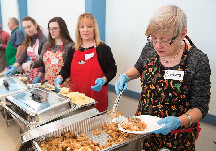 Volunteer Barbara Robin serves up some stuffing on Christmas Day at Sacred Heart Auditorium during St. Vincent de Paul’s annual Christmas Day traditional turkey dinner. Citizen Photo by James Doyle