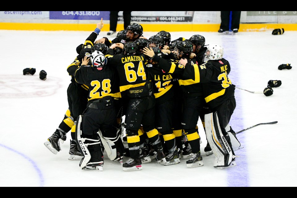 The Burnaby Winter Club Academy's bantam prep squad celebrates after Brandon Lisowsky had scored in the first minute of overtime, giving the club the title at the Pat Quinn Classic tournament on Saturday.