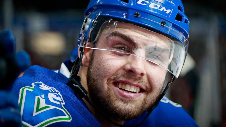 Michael Chaput smiles on the Canucks bench
