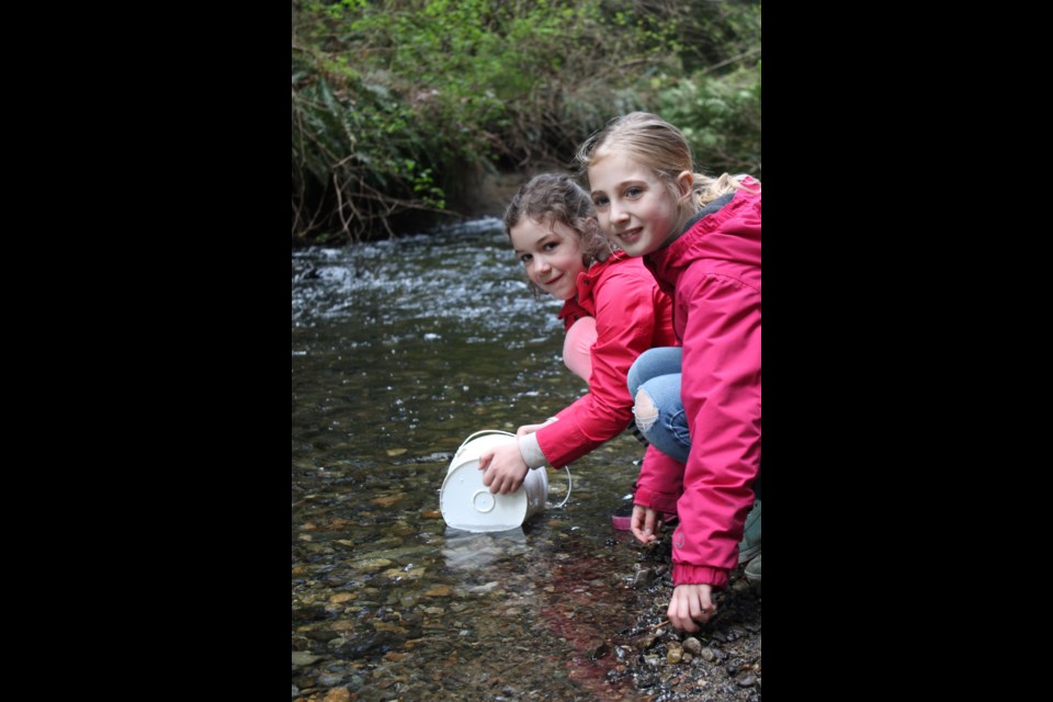 Students Delilah and Ella release salmon