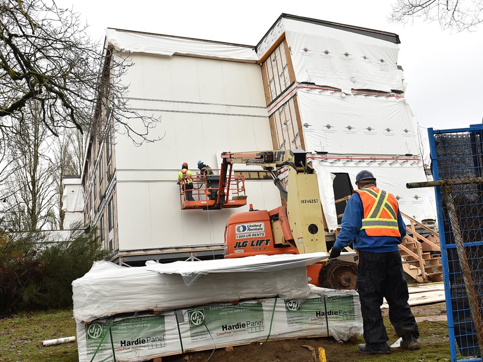 Construction crews were busy Monday assembling a 78-unit modular housing complex that will be home t