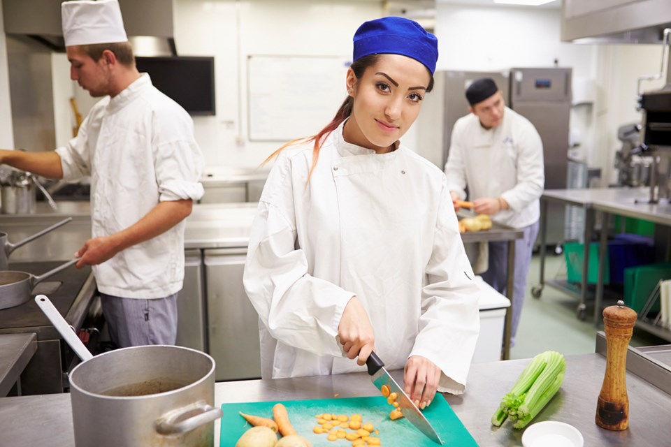 happy young chef in restaurant kitchen