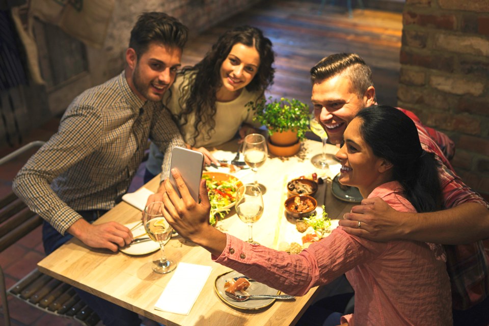 Young people taking a selfie in a restaurant.