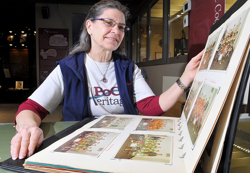 MARIO BARTEL/THE TRI-CITY NEWS
Julie Schmidt, the president of PoCo Heritage, leafs through an album of old team photos from Port Coquitlam Minor Hockey, one of the artifacts donated by members of the community to a new exhibit at the Heritage Museum about the city's sporting stories.