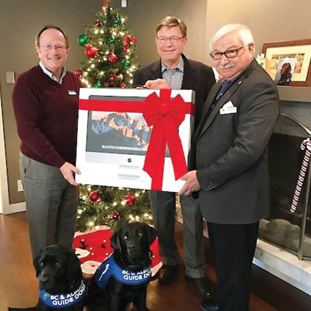 Ladner-based BC & Alberta Guide Dogs received a donation from the Delta Foundation that allowed it to purchase a new computer. BC & Alberta Guide Dogs chief executive officer Bill Thornton (left), with the help of two Guide Dogs in training, receives the new computer from Delta Foundation board directors Peter Roaf (centre) and Guillermo Bustos. BC & Alberta Guide Dogs breeds, raises and professionally trains guide dogs for visually-impaired individuals and autism support dogs for children and their families living with profound autism. It takes two years and upwards of $35,000 to produce one certified dog, provided free of charge to the recipient.