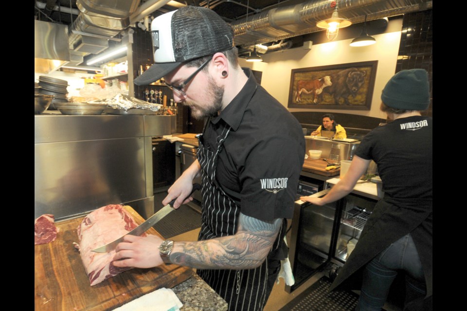 Windsor Meats butcher John Hart prepares ribeye steaks in the kitchen at The Meatery.