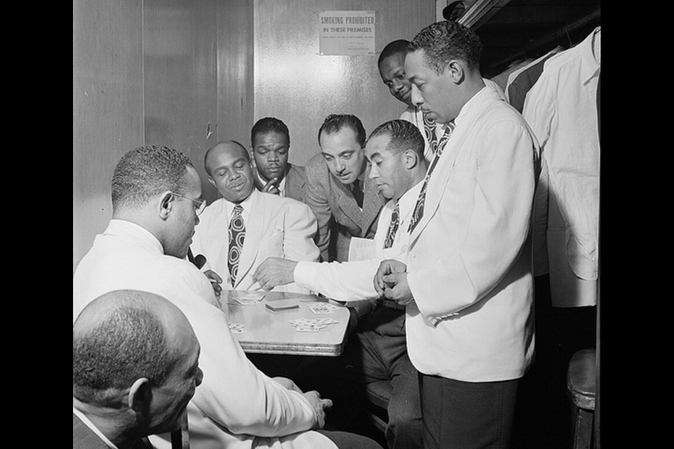 Django Reinhardt (centre) watches a poker game at the Aquarium with members of Duke Ellington’s band (Al Sears, Shelton Hemphill, Junior Raglin, Reinhardt, Lawrence Brown, Harry Carney, and Johnny Hodges) in 1946.