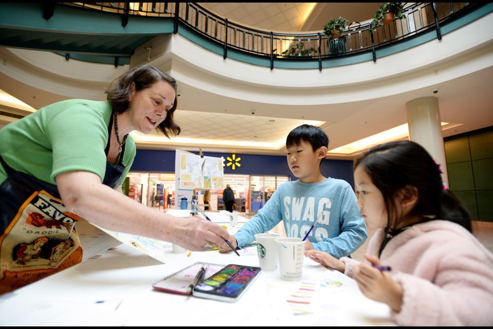 Merril Hall works with Joanna Hao 4 and Brandon, 8.