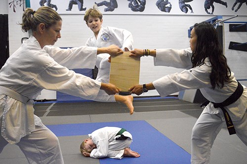 William Levis leaps up into the air and breaks a board with a well-placed flying kick.