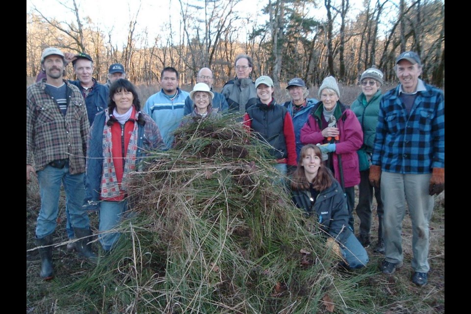 Participants in a past Broom Bash event with some of the fruits of their labours.