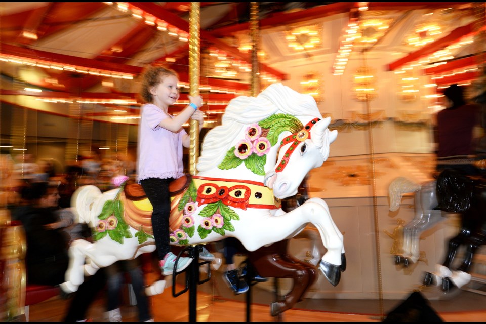 Five-year-old Ellie has fun on the vintage C.W. Parker Carousel at Burnaby Village Museum for Family Day.