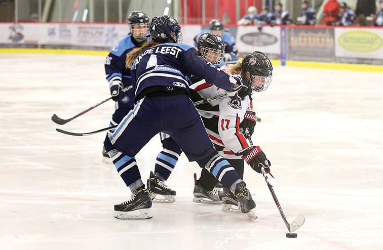 Northern Captials forward Braxtyn Shawara slides through the checks of Thompson-Okanagan Lakers defenders Adriana Van de Leest (#4) and Danielle Selby (#15) on Sunday morning at Kin 1. Citizen Photo by James Doyle