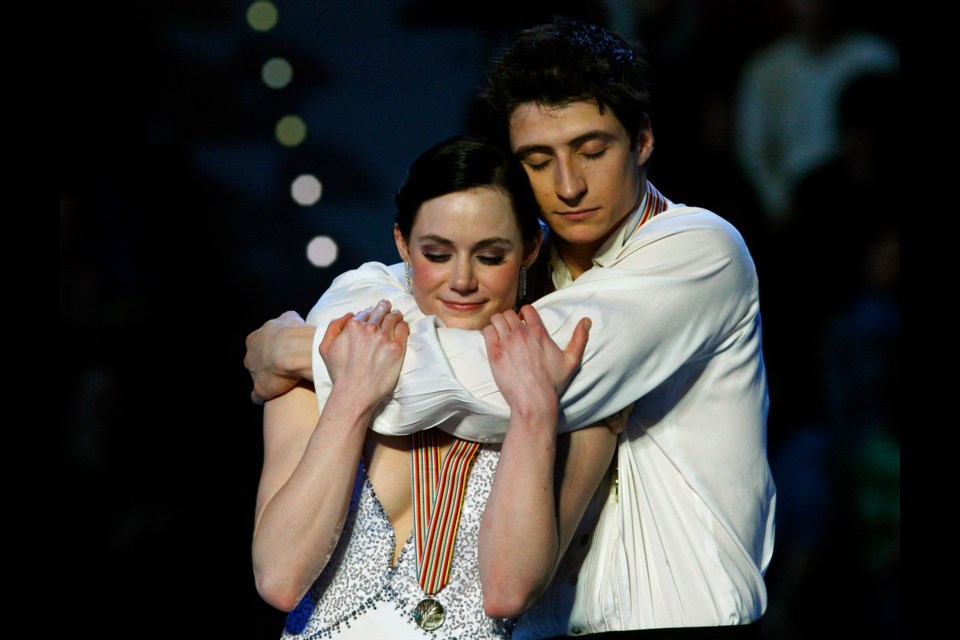 Tessa Virtue and Scott Moir of Canada react on the podium after winning the gold medal in the ice dance competition, at the World Figure Skating Championships in Turin, Italy, Friday, March 26, 2010.
