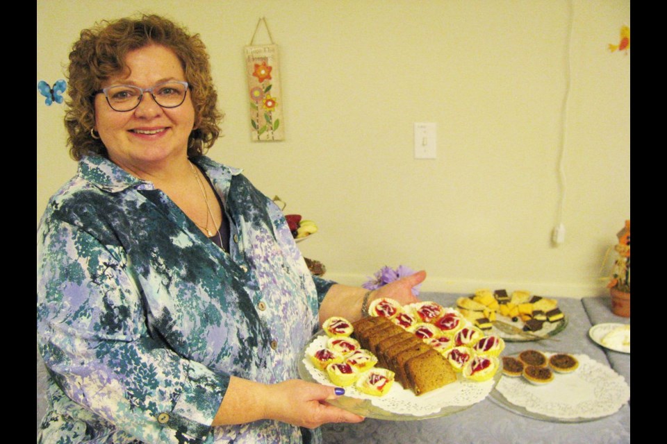 Dianne Graham, organizer of the Order of the Eastern Star Leap Into Spring Tea and Auction held Sunday afternoon at the Masonic Hall displays some of the goodies that were available during the fundraising event.