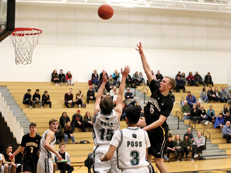 Duchess Park Condors post Cody Boulding flings the ball over the outstretched arms of Jordan Foster of the Prince George Polars during their game Saturday at the North Central zone triple-A boys basketball championship game Saturday at Duchess Park. Boulding shot a game-high 28 points in a 102-77 win.