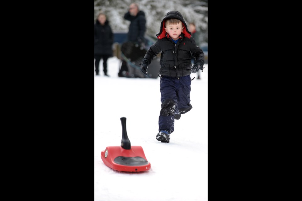 Eli Arason, 7, chases his sled down a slope.