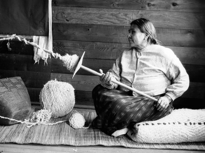 Musqueam weaver Selisya spinning wool using a traditional spindle whorl. Photograph by Charles F. Newcombe on a field trip with Mary Lois Kissell, Dec. 5, 1915.