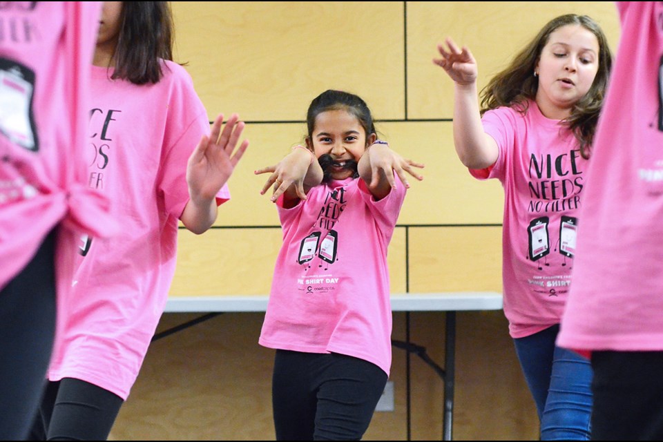 Montecito Elementary leadership students Kaniraa Ainkaran and Natasha Piccolo bust some moves during a pre-Pink Shirt Day flash mob at a Burnaby board of education meeting Monday.