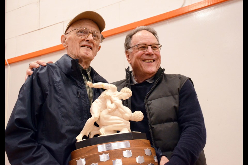 Harvey Tuura, left, and former New West Secondary coach Barry Callaghan hold the trophy that came out of Tuura’s donated statue, which is the annual reward for the best boys team at the B.C. High School wrestling championships.