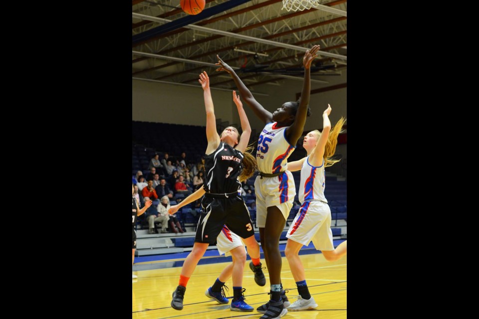 New Westminster Hyacks' Jamie Butts, left, battles for a rebound with Semiahmoo's Faith Dut during the opening game at the B.C. 3-A senior girls basketball championships in Langley.