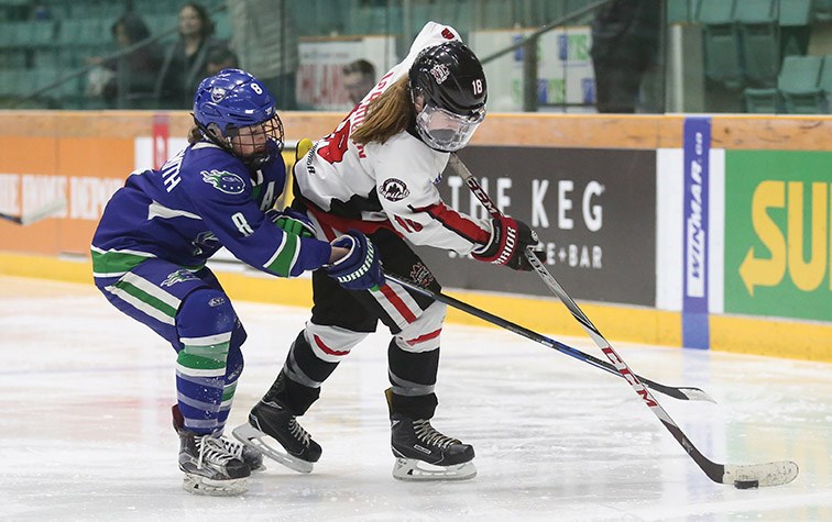 Northern Capitals forward Danielle Corrigan controls the puck while being checked by Greater Vancouver Comets defender Nina Jobst-Smith on Sunday at CN Centre in the final game of a weekend triple-header between the two teams. Citizen Photo by James Doyle