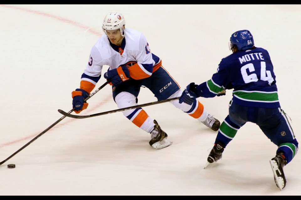 Burnaby Winter Club alumnus Mathew Barzal, of the New York Islanders, tries to wheel around Vancouver Canucks' forward Tyler Motte Monday at Roger's Arena. The game was Barzal's first in Vancouver as an NHLer.