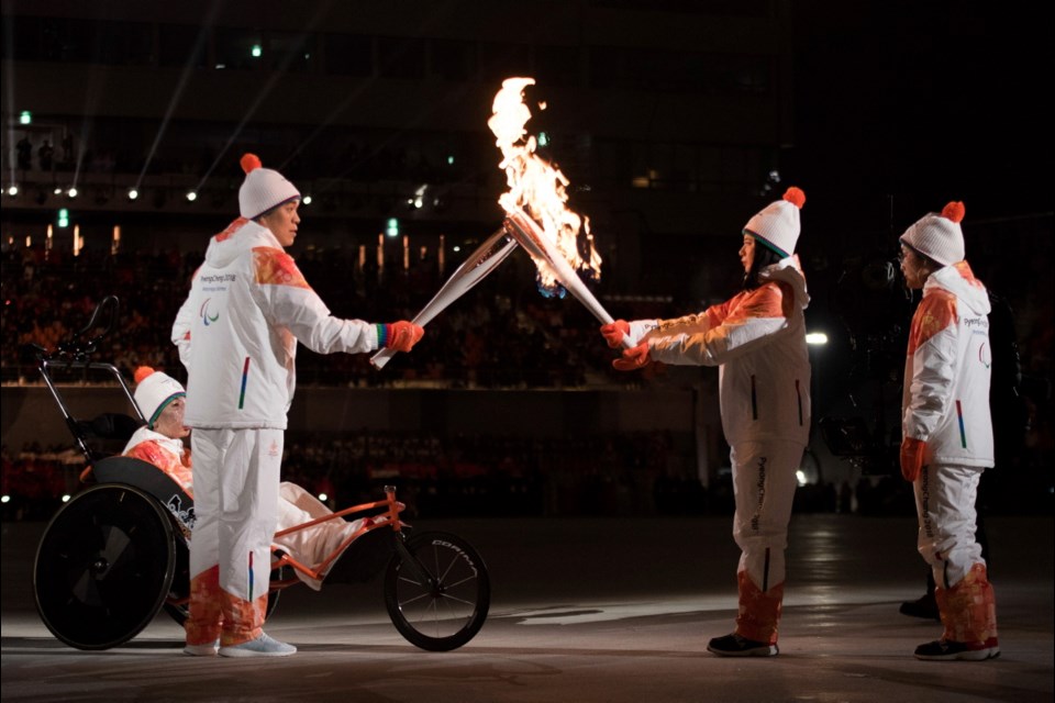 Seo Soonseok and Kim EunJung of Korea take the flame during the opening ceremony for the XII Paralympic Winter Games in the Pyeongchang Olympic Stadium in Pyeongchang, South Korea, Friday, March 9, 2018.