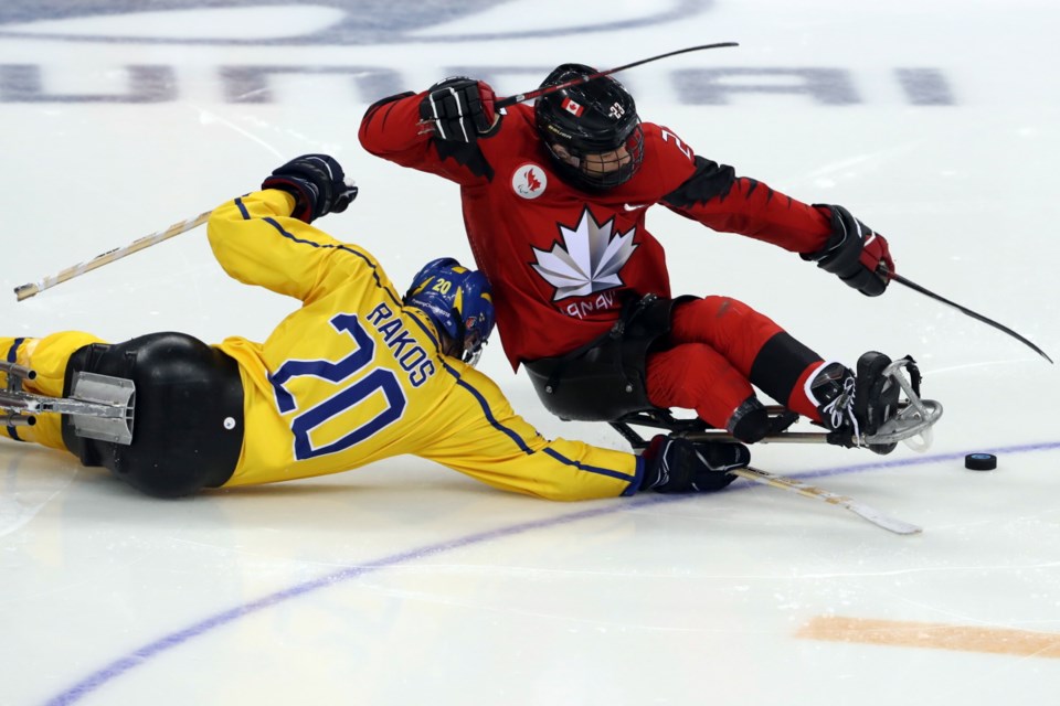 Canada's Liam Hickey in red keeps the puck away Sweden's Niklas during a preliminary round for the 2018 Winter Paralympics held at the Gangneung Hockey Centre in Gangneung, South Korea, Saturday, March 10, 2018.