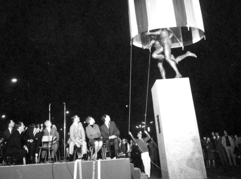 Dignitaries watch as a curtain is pulled up to reveal the Miracle Mile statue by sculptor Jack Harm