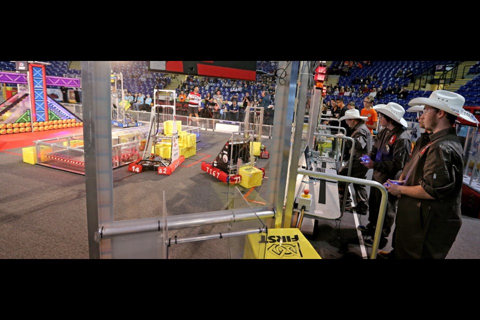 Cowboy-hat-wearing members of Calgary's Team Ghosts — from left, Jessica Rimes, Ian Riley, Martin Riley and Seth Hughes — manoeuvre their robot at the Canadian Pacific Regional First Robotics Competition at Save-on-Memorial Centre. The event winds up Friday.