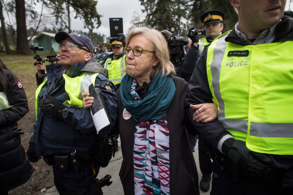 Green Party Leader Elizabeth May, centre, is arrested by RCMP officers after joining protesters outside Kinder Morgan's facility in Burnaby, B.C., on Friday, March 23, 2018.