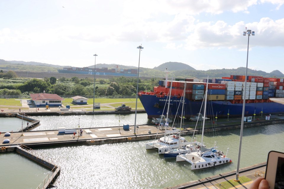 A container ship and several sailing boats wait to cross Miraflores Lock, Panama Canal. It&Otilde;s a quiet and easy trip for cyclists on tour.