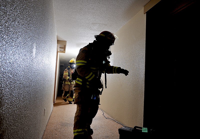 MARIO BARTEL/THE TRI-CITY NEWS
Coquitlam firefighters prepare to enter a burning suite on the second floor of a vacant apartment building during a training exercise on Wednesday. Firefighters use powerful fans to clear smoke from hallways and also create a higher air pressure in the hallway so they don't fill with smoke when they open the doors to suites to check for trapped occupants.