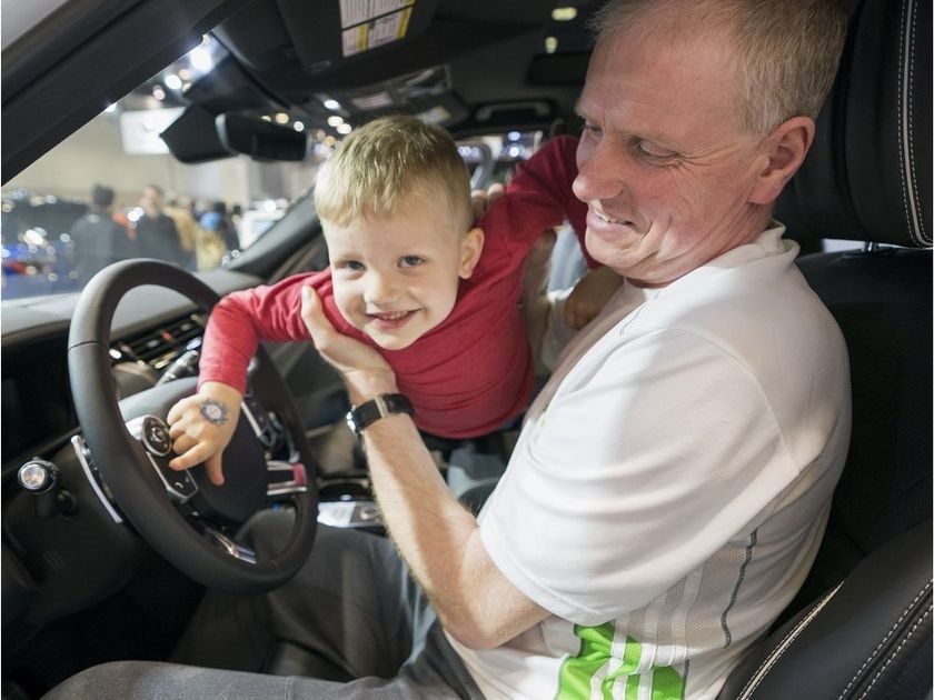 Andy Kettley and his grandson Landyn sit in a Land Rover while visiting the 2018 Vancouver International Auto Show.